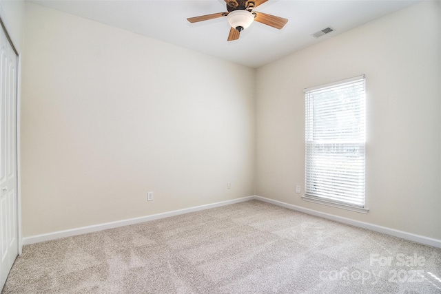 spare room featuring carpet flooring, a ceiling fan, baseboards, and visible vents
