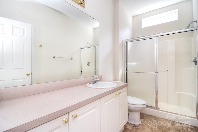 bathroom with toilet, a shower stall, and vanity
