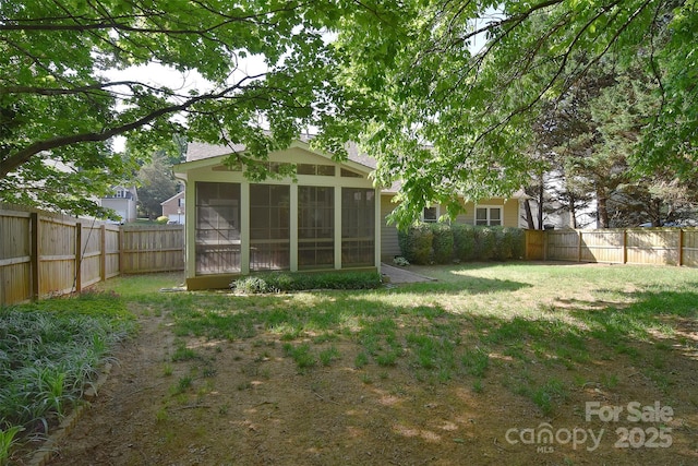view of yard featuring a sunroom and a fenced backyard