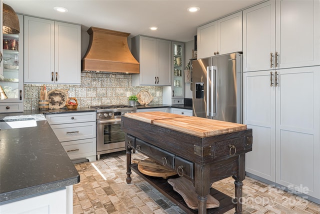 704 Fleetwood Plz, Hendersonville, NC 28739 - kitchen with appliances with stainless steel finishes, premium range hood, brick patterned flooring, tasteful backsplash, and recessed lighting