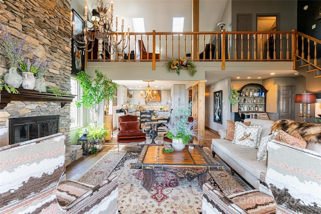 704 Fleetwood Plz, Hendersonville, NC 28739 - living room featuring a chandelier, a towering ceiling, wood finished floors, a fireplace, and stairs