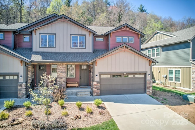 craftsman inspired home featuring concrete driveway, stone siding, board and batten siding, and a garage