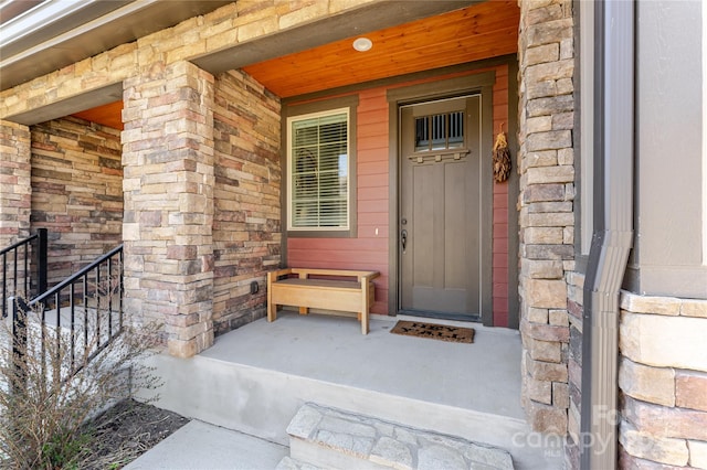 property entrance with stone siding and covered porch