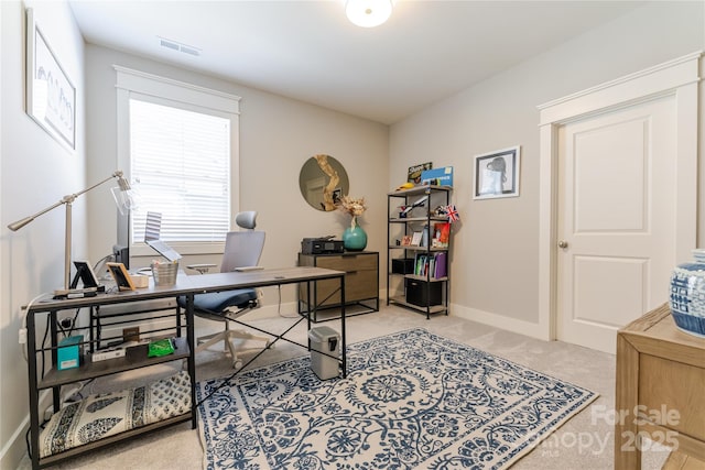 office space featuring light carpet, baseboards, and visible vents