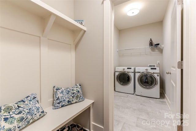 laundry room with washing machine and dryer, baseboards, and laundry area