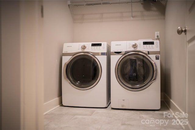 laundry room with washing machine and dryer, baseboards, and laundry area