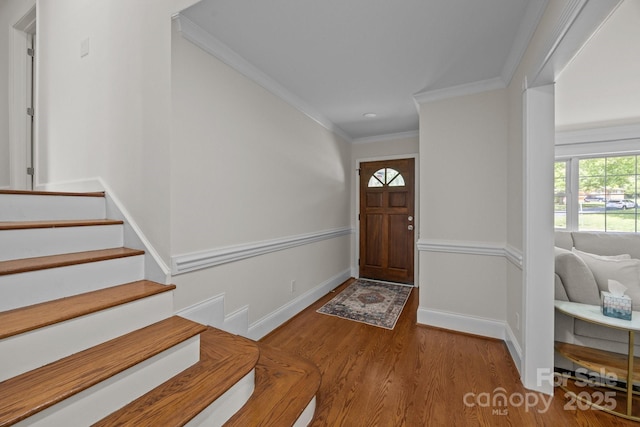 entrance foyer featuring baseboards, wood finished floors, stairs, and ornamental molding