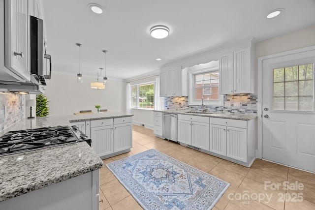 kitchen with backsplash, stainless steel dishwasher, and light tile patterned flooring