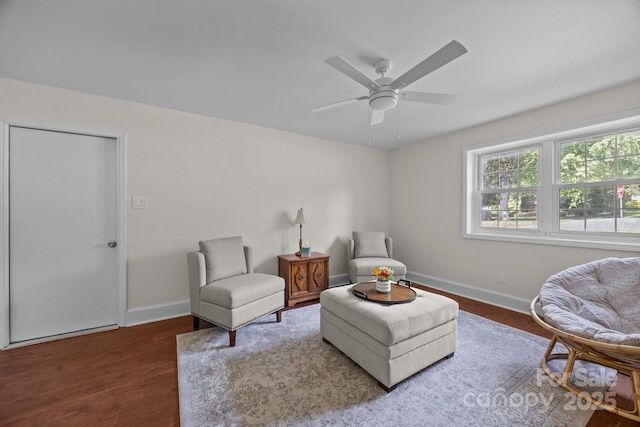 living area with wood finished floors, baseboards, and ceiling fan
