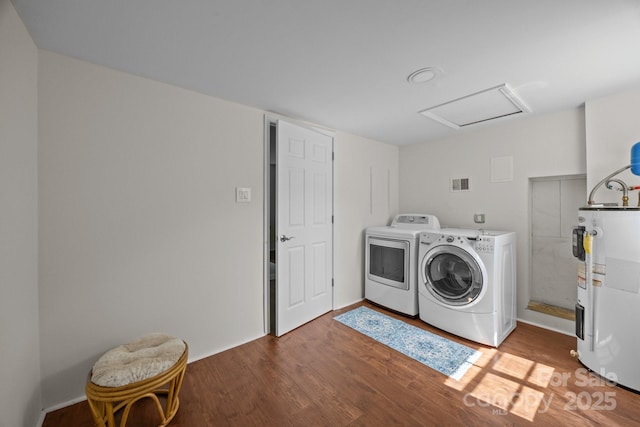 laundry area with separate washer and dryer, attic access, wood finished floors, and water heater