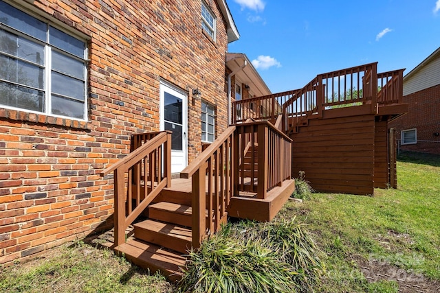 wooden deck with stairway and a yard