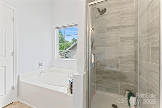 full bath featuring a bath and a shower stall