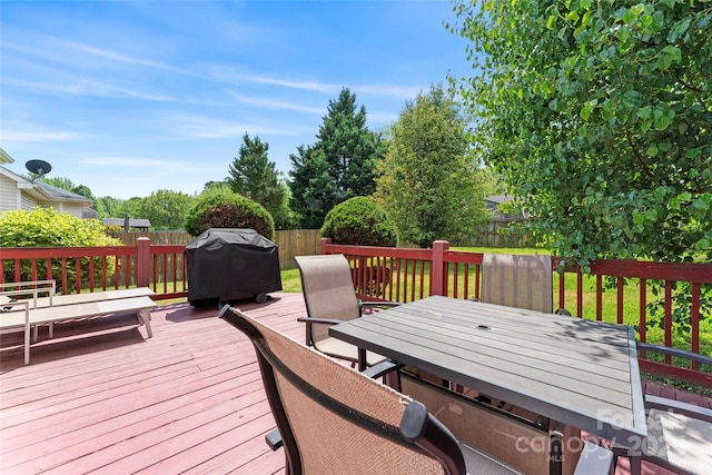 wooden terrace with a fenced backyard, outdoor dining space, and area for grilling