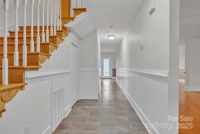 63 Frost Ln, Taylorsville, NC 28681 - hallway featuring a wainscoted wall, stairs, and a decorative wall