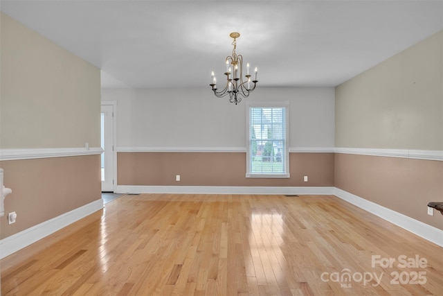 63 Frost Ln, Taylorsville, NC 28681 - spare room with light wood-style floors, a chandelier, and baseboards