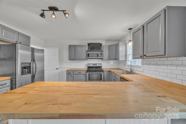63 Frost Ln, Taylorsville, NC 28681 - kitchen featuring stainless steel appliances, butcher block countertops, gray cabinets, a sink, and decorative backsplash