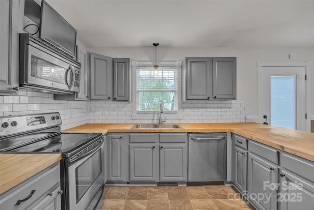 63 Frost Ln, Taylorsville, NC 28681 - kitchen featuring butcher block countertops, appliances with stainless steel finishes, a sink, gray cabinetry, and tasteful backsplash
