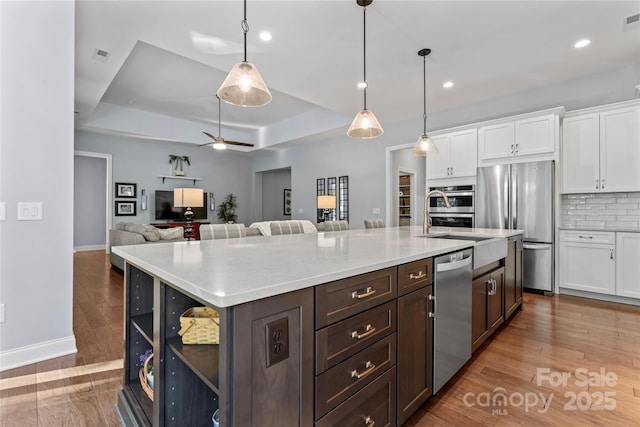 4012 Brandywine Ter, Lancaster, SC 29720 - kitchen featuring a tray ceiling, dark brown cabinetry, white cabinetry, light countertops, and appliances with stainless steel finishes