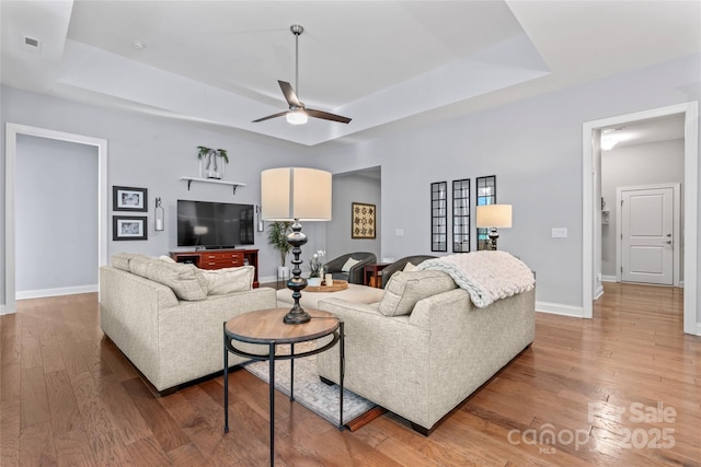 4012 Brandywine Ter, Lancaster, SC 29720 - living area with wood finished floors, baseboards, visible vents, a raised ceiling, and a ceiling fan