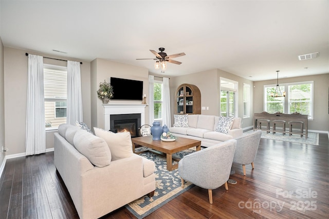 3028 Quinebaug Rd, Fort Mill, SC 29715 - living area featuring a ceiling fan, dark wood finished floors, visible vents, baseboards, and a glass covered fireplace