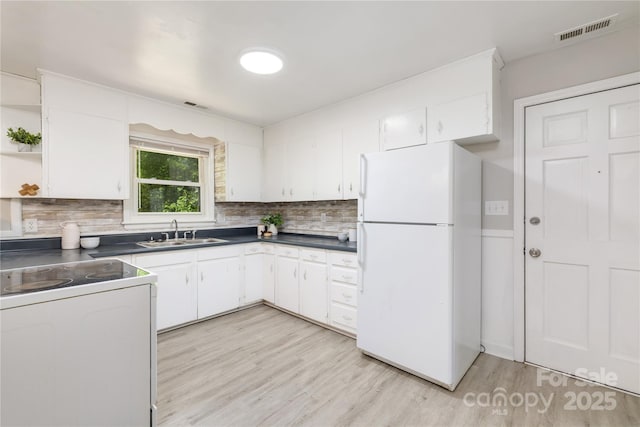 kitchen featuring visible vents, white appliances, a sink, and tasteful backsplash