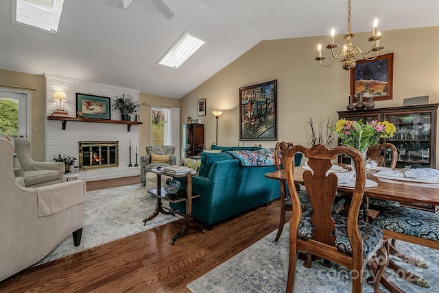 104 Parkway Ct Unit 1, Asheville, NC 28803 - dining space with vaulted ceiling with skylight, a fireplace, wood finished floors, and a healthy amount of sunlight