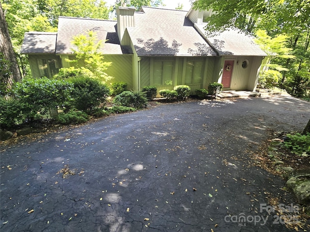 124 Cardinal Rd, Lake Lure, NC 28746 - view of front facade with driveway, a chimney, and roof with shingles