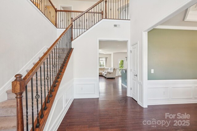 5037 Nighthawk Dr, Fort Mill, SC 29707 - stairway with wood finished floors, a wainscoted wall, a towering ceiling, a decorative wall, and crown molding