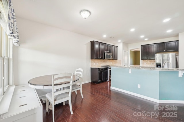 5037 Nighthawk Dr, Fort Mill, SC 29707 - kitchen with stainless steel appliances, backsplash, dark wood finished floors, light stone counters, and recessed lighting