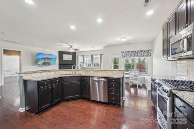 5037 Nighthawk Dr, Fort Mill, SC 29707 - kitchen featuring stainless steel appliances, ceiling fan, backsplash, a sink, and dark wood-type flooring