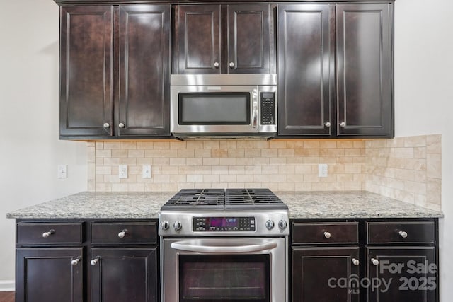 5037 Nighthawk Dr, Fort Mill, SC 29707 - kitchen with stainless steel appliances, tasteful backsplash, dark brown cabinets, and light stone counters