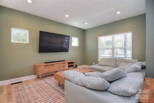 living area with recessed lighting, light wood finished floors, and a healthy amount of sunlight