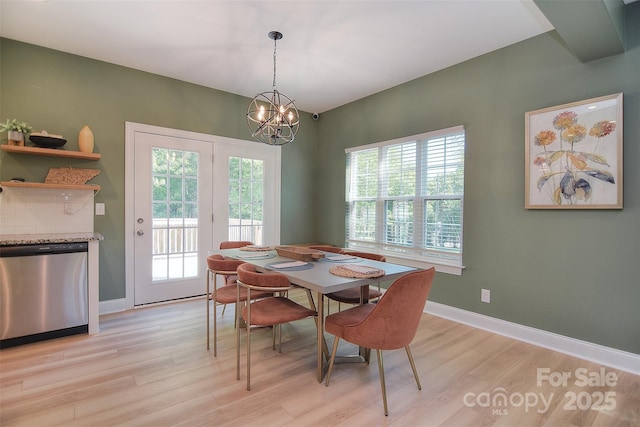 dining area with an inviting chandelier, baseboards, and light wood-type flooring