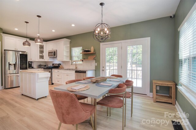 dining space with light wood-style floors, recessed lighting, a toaster, and an inviting chandelier