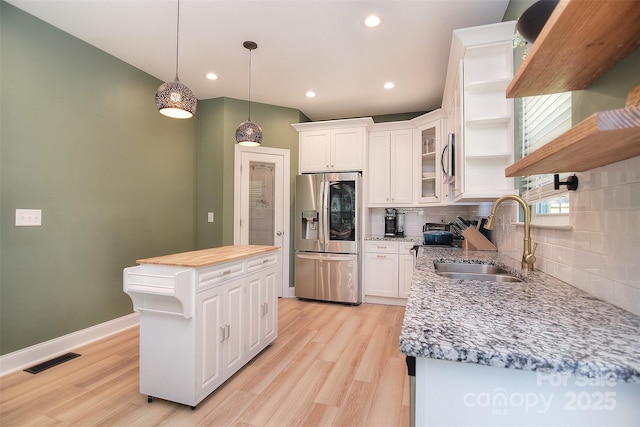 kitchen with open shelves, a sink, white cabinetry, backsplash, and stainless steel refrigerator with ice dispenser