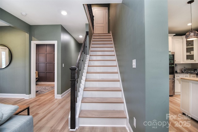 stairway with baseboards, recessed lighting, wood finished floors, and a toaster