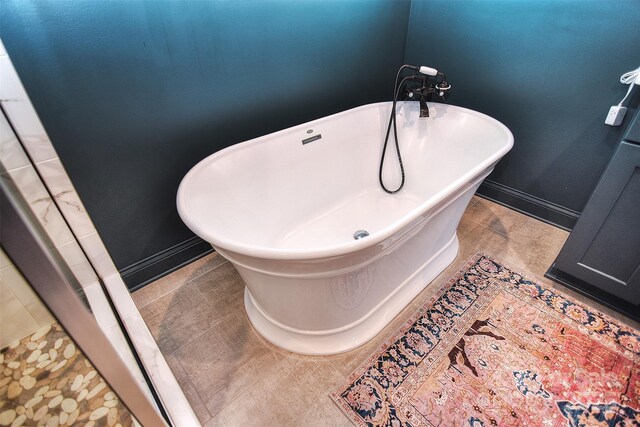 bathroom featuring baseboards and a freestanding bath