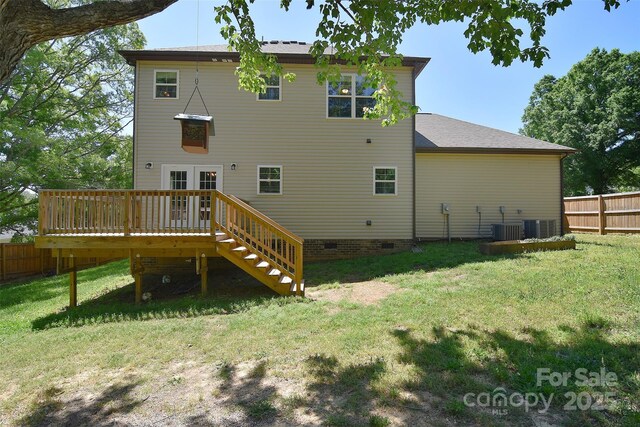 rear view of house featuring a lawn, crawl space, fence, and a deck