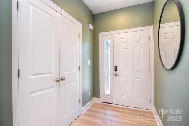 foyer with baseboards and light wood finished floors