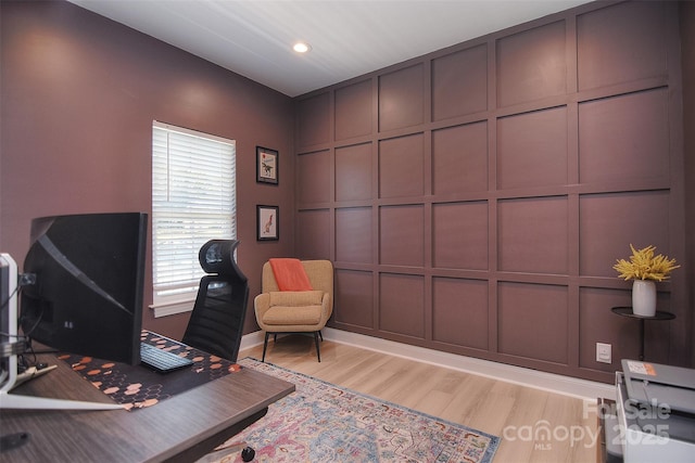 office area featuring baseboards, a decorative wall, recessed lighting, and light wood-style flooring