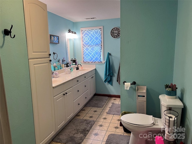 541 Pilgrim Rd, Ellenboro, NC 28040 - bathroom with visible vents, a sink, toilet, a textured wall, and double vanity