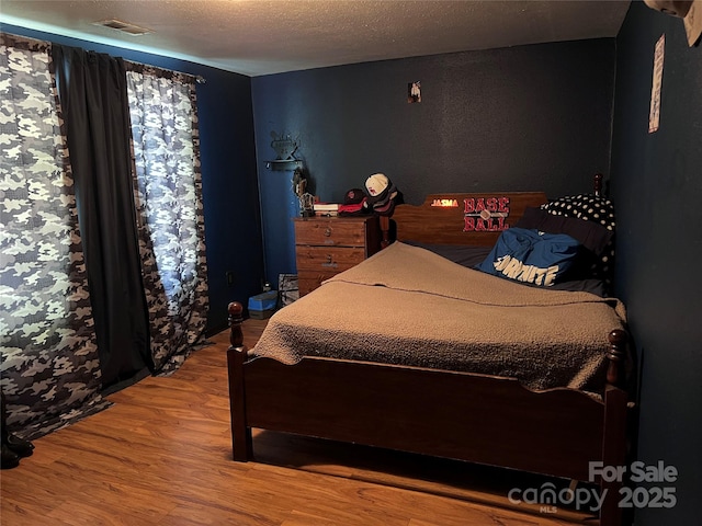 541 Pilgrim Rd, Ellenboro, NC 28040 - bedroom with visible vents, a textured ceiling, and wood finished floors