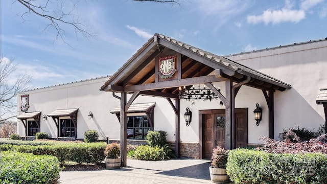 exterior space featuring stucco siding and stone siding
