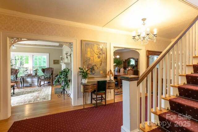 88 S Main St, Weaverville, NC 28787 - stairway featuring arched walkways, a notable chandelier, ornamental molding, and wood finished floors
