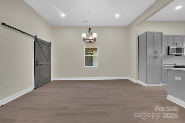 126 Hemphill Ave, Chester, SC 29706 - unfurnished dining area with a chandelier, wood finished floors, a barn door, baseboards, and recessed lighting