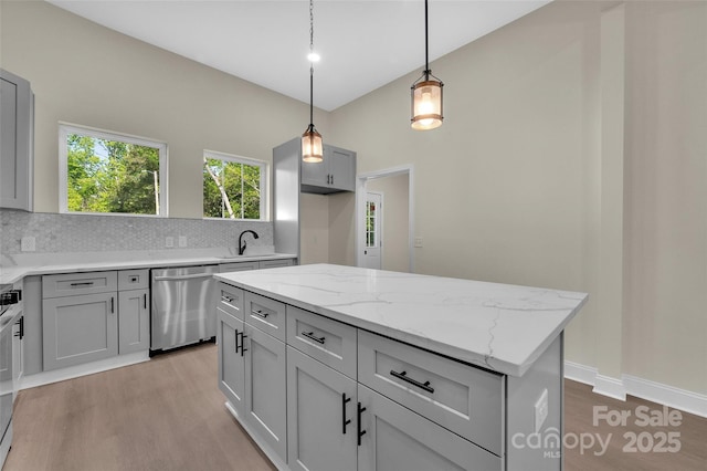 126 Hemphill Ave, Chester, SC 29706 - kitchen featuring stainless steel dishwasher, light wood-style flooring, a sink, tasteful backsplash, and light stone countertops