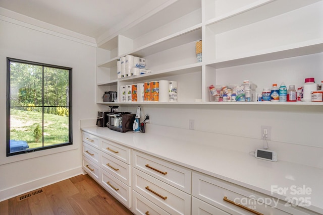 153 High Hills Dr, Mooresville, NC 28117 - kitchen with open shelves, light wood finished floors, light countertops, and white cabinetry