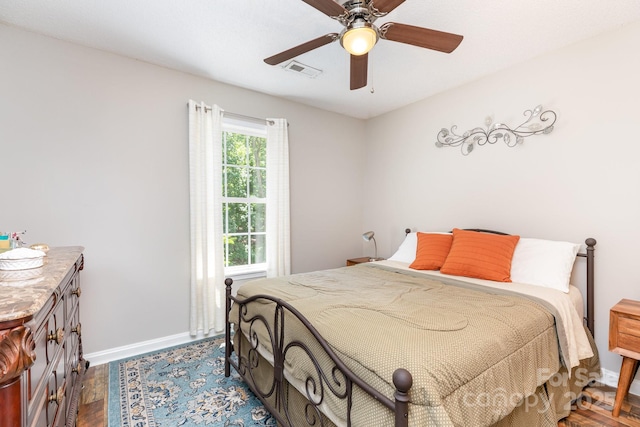 bedroom with baseboards, dark wood-type flooring, and a ceiling fan