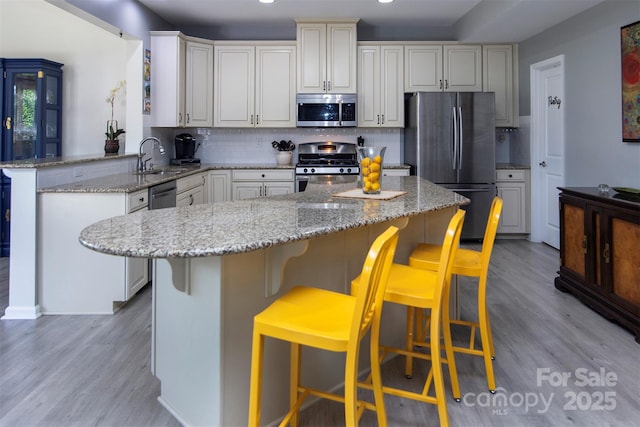 7397 Mill Ruins Ave SW, Concord, NC 28025 - kitchen featuring appliances with stainless steel finishes, a peninsula, light wood finished floors, backsplash, and recessed lighting