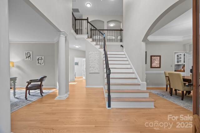 263 Fernbrook Dr, Mooresville, NC 28117 - stairway featuring decorative columns, arched walkways, wood finished floors, baseboards, and a high ceiling
